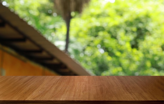 La mesa de madera vacía frente al fondo borroso abstracto de la cafetería se puede usar para exhibir o montar sus productos Maqueta para exhibir el producto