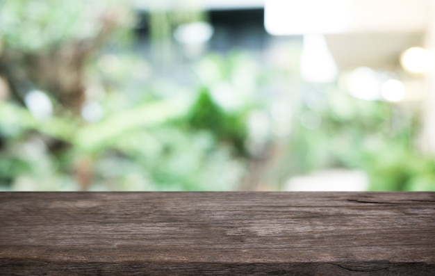 Mesa de madera vacía frente al fondo borroso abstracto de la mesa de madera de la cafetería en el frente se puede utilizar para mostrar o montar sus productos