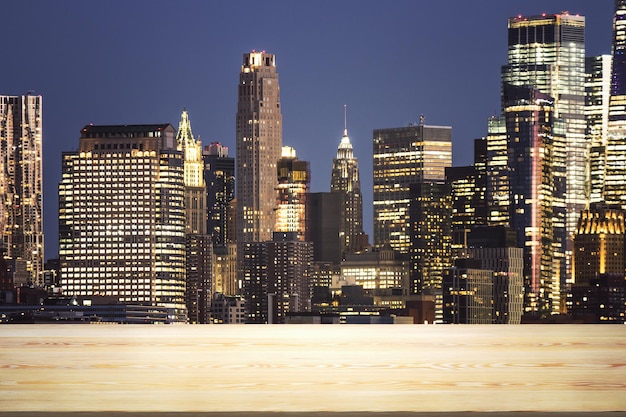 Mesa de madera vacía con hermosos rascacielos de Nueva York por la noche en maqueta de fondo