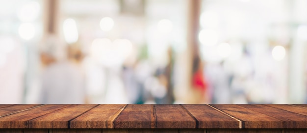 Mesa de madera vacía y mesa de luz borrosa en centro comercial con fondo bokeh. plantilla de visualización de productos.