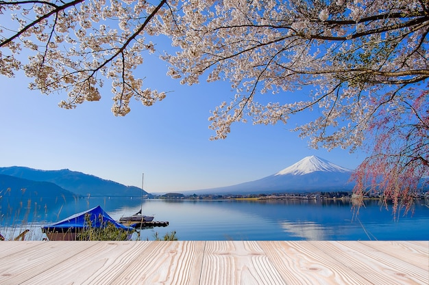 Mesa de madera vacía con la montaña Fuji y un hermoso fondo de flor de cerezo rosa en la temporada de primavera