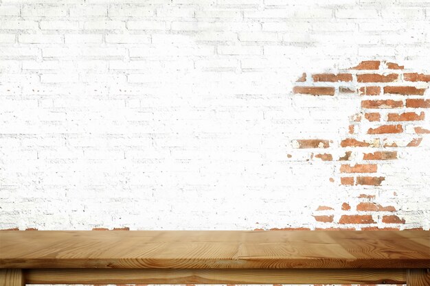 Mesa de madera vacía y pared de ladrillo blanco.