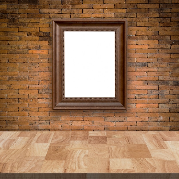 Mesa de madera vacía y pared de ladrillo rojo con imagen de marco