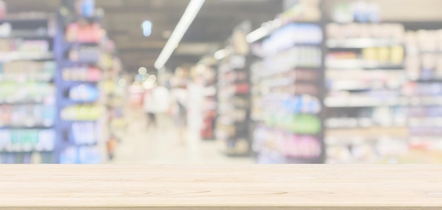 Mesa de madera vacía con pasillo de supermercado con estantes de productos interior desenfocado fondo borroso