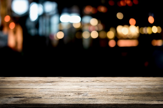 Mesa de madera vacía plataforma y bokeh en la noche