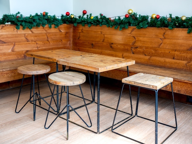 Mesa de madera vacía y sillas de madera con interior de adornos de objetos de adorno de Navidad.