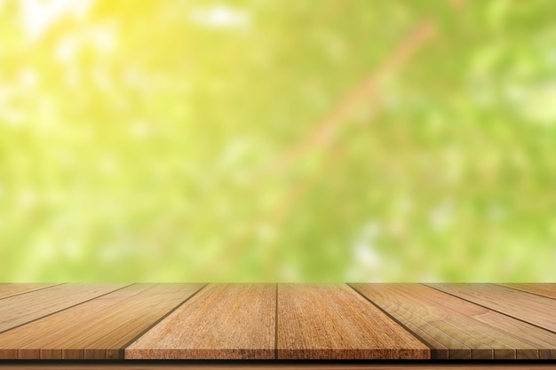 Mesa de madera vacía sobre un fondo borroso de naturaleza verde para la exhibición de productos