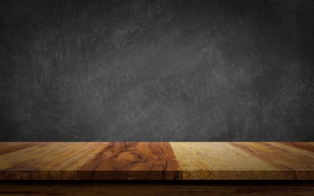 Mesa de madera vacía sobre fondo de pizarra.