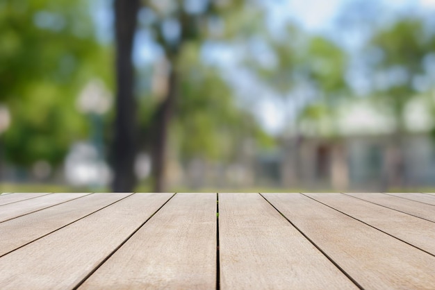 Mesa de madera vieja vacía sobre un árbol abstracto borroso del jardín por la mañana.