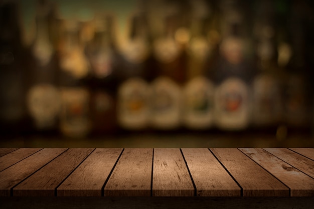 Mesa de madera con vistas al fondo borroso de la botella de la barra de bebidas.