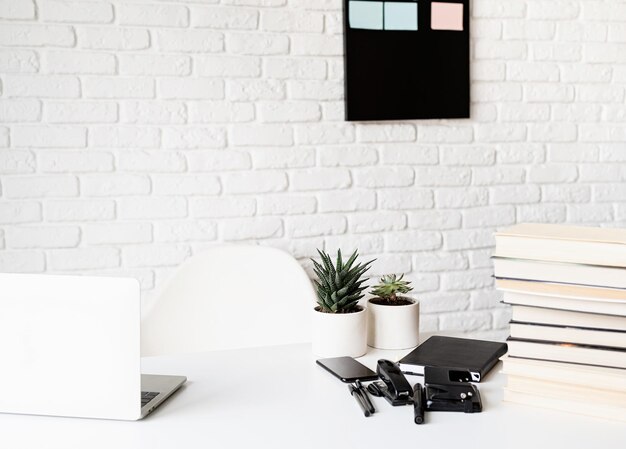 Foto mesa de maestros con libros portátiles y papelería