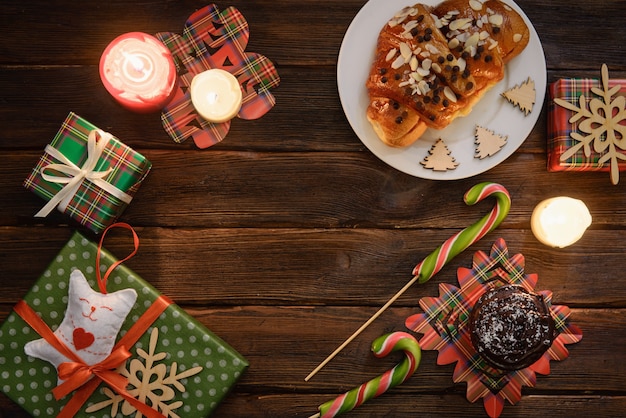 Mesa de la mañana de Navidad con croissant (panadería), dulces y regalos. Vista superior de regalos navideños, decoración.