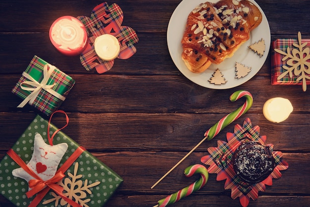 Mesa de la mañana de Navidad con croissants, dulces y regalos.