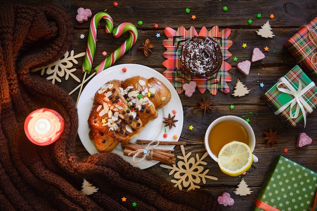 Foto mesa de la mañana de navidad con croissants, dulces y regalos.