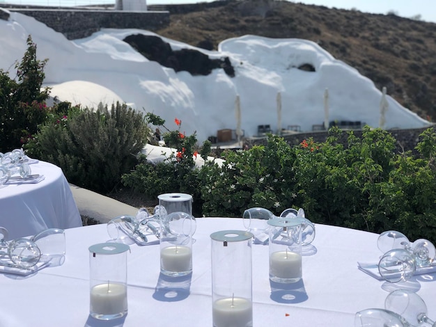 Foto una mesa con un mantel blanco con una vela y gafas en ella