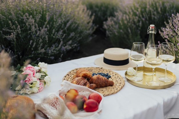 Una mesa con mantel y una botella de vino y croissants