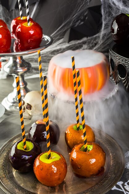 Mesa con manzanas de caramelo de colores para la fiesta de Halloween.