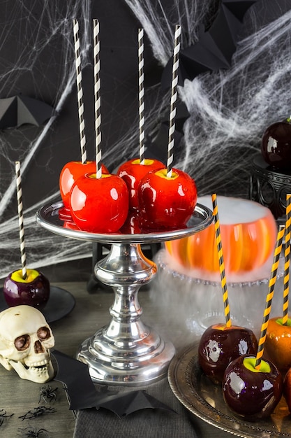 Mesa con manzanas de caramelo de colores para la fiesta de Halloween.