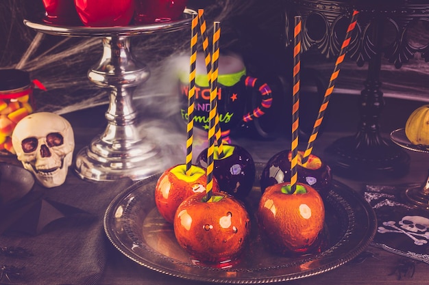 Mesa con manzanas de caramelo de colores para la fiesta de Halloween.