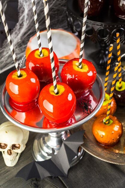 Mesa con manzanas de caramelo de colores para la fiesta de Halloween.