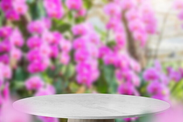 Mesa de mármol vacía con fondo borroso de jardín de orquídeas para la exhibición de productos