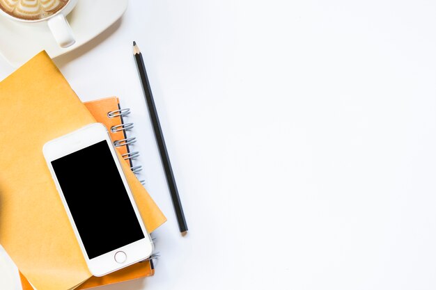 Foto mesa na vista superior do escritório. lápis com notebook e smartphone com café na isolada