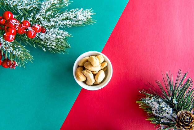 Mesa de Navidad con anacardos sobre un fondo verde y rojo.