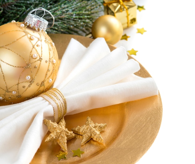 Mesa de Navidad en dorado con decoraciones de Navidad y ramas de cerca aisladas en blanco