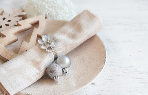 Mesa de Navidad de plata y crema en una mesa de madera blanca