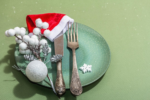 Mesa de Navidad con platos de cerámica decoración tradicional sobre fondo de color verde sabana