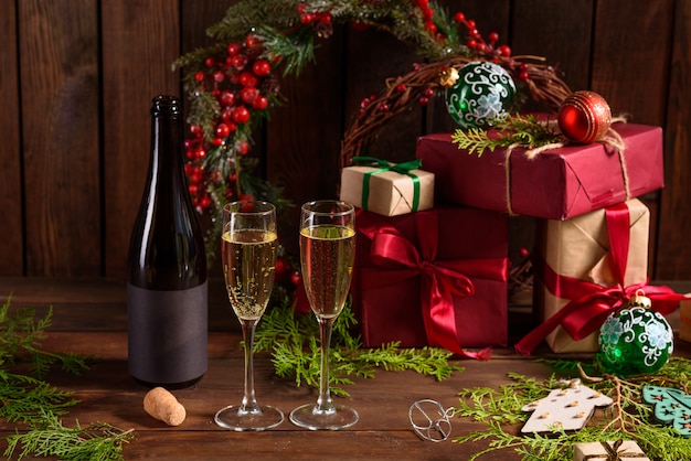 Mesa navideña con copas y una botella de vino de champagne