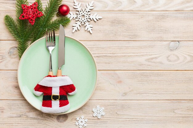 Mesa navideña con decoración navideña y platos kine tenedor y cuchara Fondo navideño Vista superior con espacio de copia