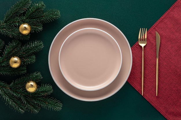 Mesa navideña con decoraciones de Año Nuevo Platos vacíos y cubiertos dorados en una vajilla verde oscuro Vista superior Comedor decoración festiva en un restaurante de lujo Tarjeta o plantilla de menú plana