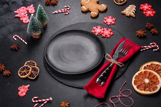 Mesa navideña con placa de cerámica negra vacía, abeto y accesorios negros