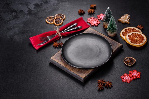 Mesa navideña con placa de cerámica negra vacía, abeto y accesorios negros