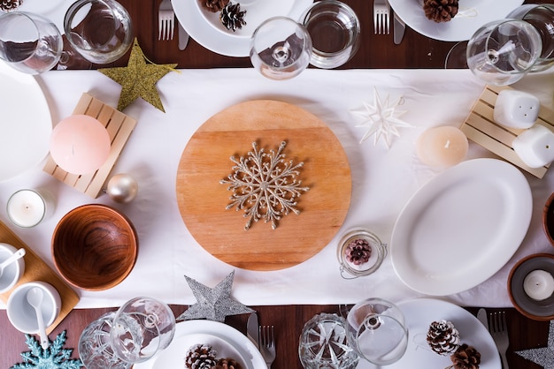 Mesa navideña con plato y decoración en mesa de madera oscura, plano
