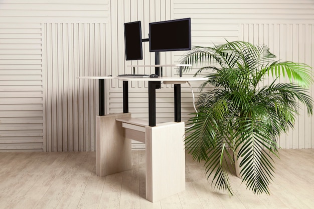 Mesa de oficina con dos monitores, un mecanismo de elevación para el soporte de un manitor y un tablero para el que se puede trabajar de pie y sentado. Mesa de oficina universal