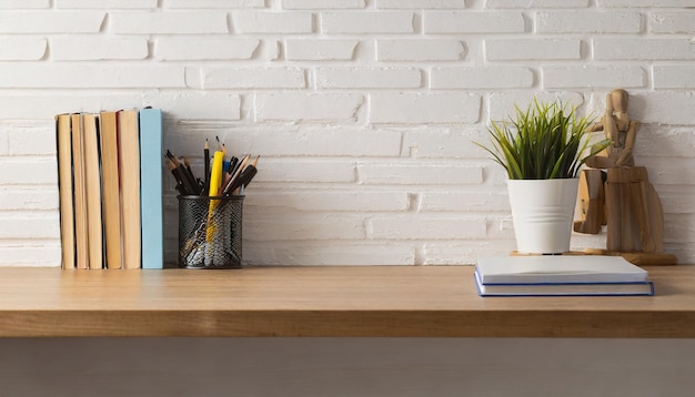 Mesa de oficina de espacio de trabajo escritorio vacío con libros y suministros contra la pared blanca espacio de copia para el texto