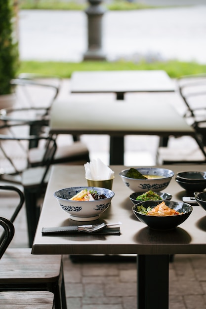 Mesa oscura servida con platos japoneses de estilo asiático