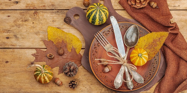 Mesa de otoño, cubertería de Acción de Gracias, decoración tradicional de otoño, disposición plana, ambiente festivo y acogedor, estilo rústico, hojas de calabaza, fondo de madera, formato de banner