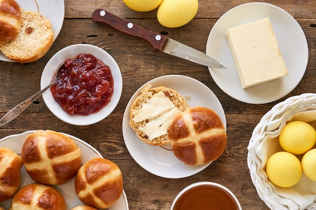 Mesa de Pascua con bollos cruzados y huevos amarillos de colores