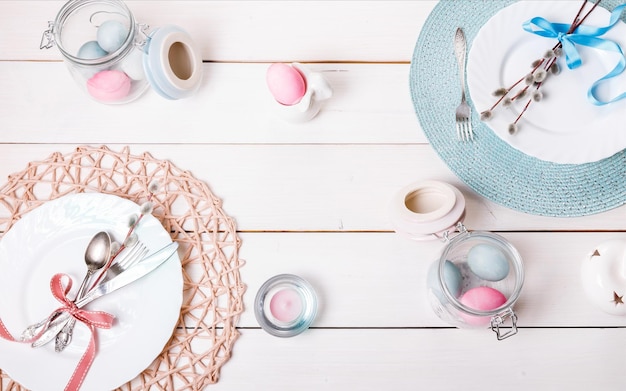 Mesa de Pascua con huevos dorados y azules y fondo de vacaciones de cubiertos