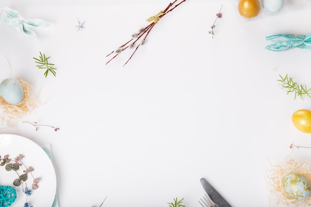 Mesa de Pascua con huevos dorados y azules y fondo de vacaciones de cubiertos