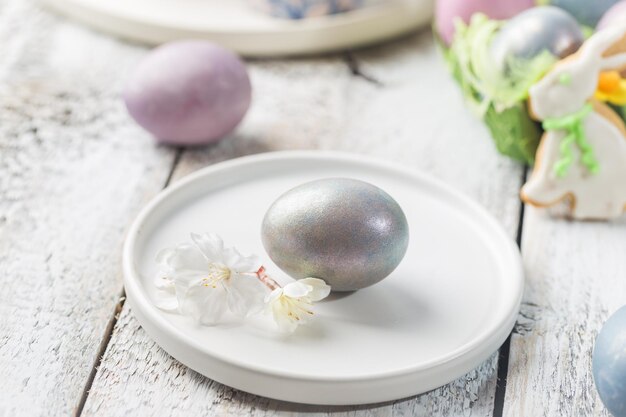 Mesa de Pascua con huevos de Pascua sobre fondo blanco.