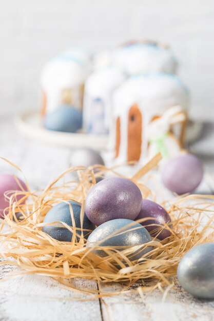 Mesa de Pascua con huevos de Pascua sobre fondo blanco.