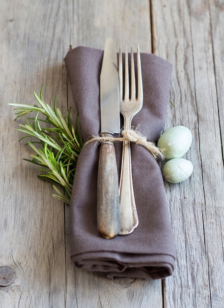 Mesa de Pascua con huevos y romero en la mesa de madera gris de cerca