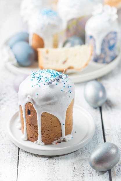 Mesa de Pascua con tortas de Pascua y huevos de Pascua sobre fondo blanco.