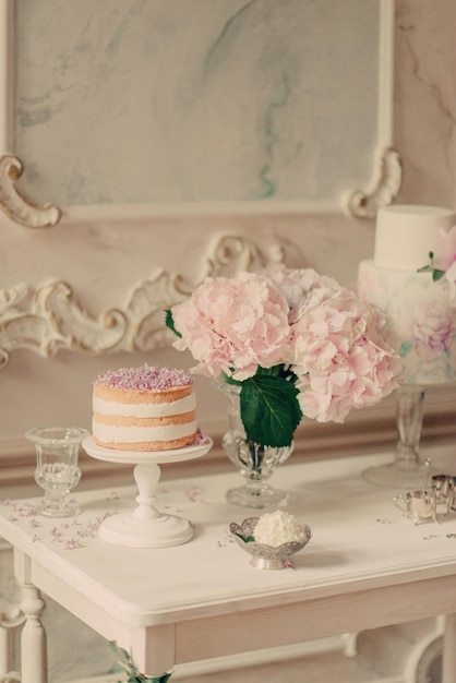 Una mesa con un pastel y flores.
