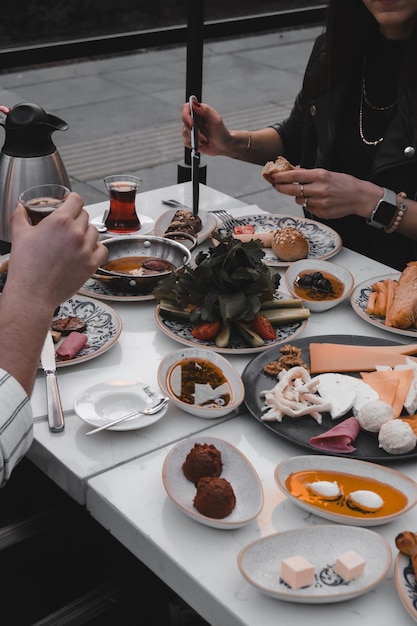 Foto una mesa con una persona comiendo comida y una persona con una camisa con una letra en ella