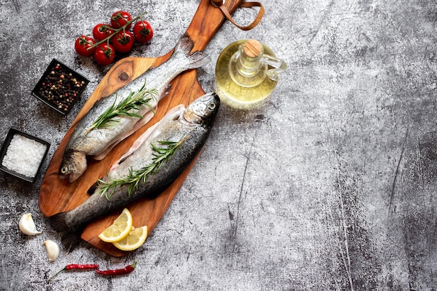 Una mesa con pescado y verduras encima.